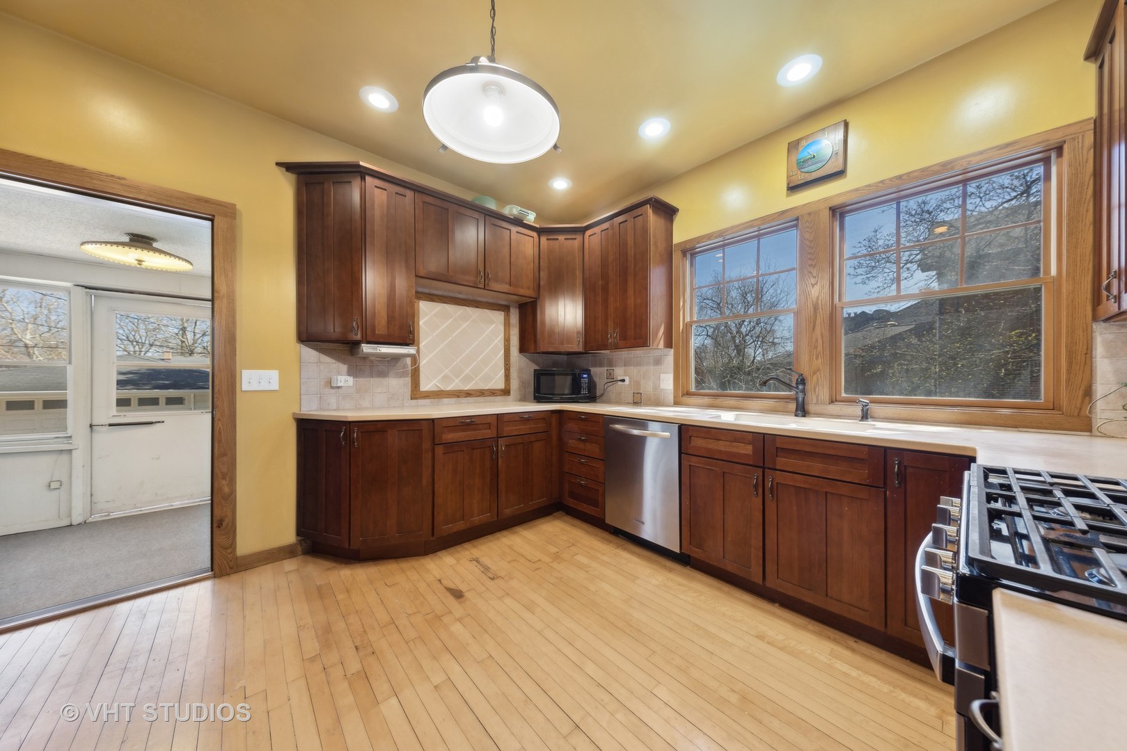 155 Geneva Avenue Elmhurst, IL 60126 - Photo 11 of 33 a large kitchen with stainless steel appliances wooden floors wooden cabinets a center island and a window