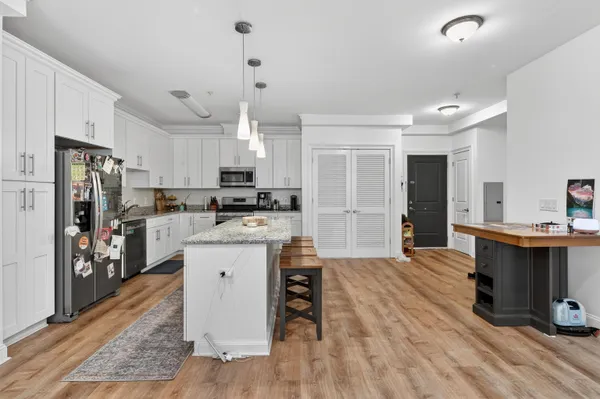 a large kitchen with kitchen island a sink a center island stainless steel appliances and a dining table