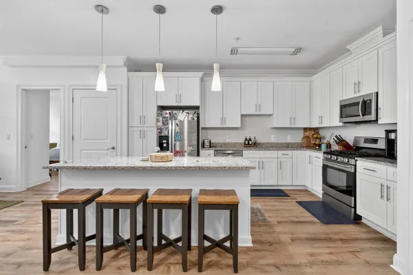 a kitchen with granite countertop a stove a sink and a refrigerator