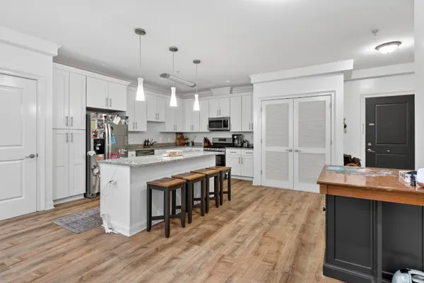 a kitchen with kitchen island granite countertop a sink cabinets and stainless steel appliances