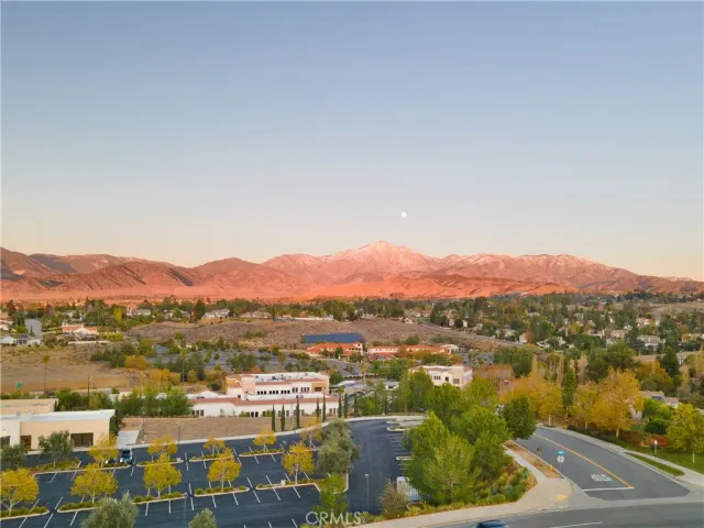 an aerial view of a city with lots of residential buildings ocean and mountain view in back