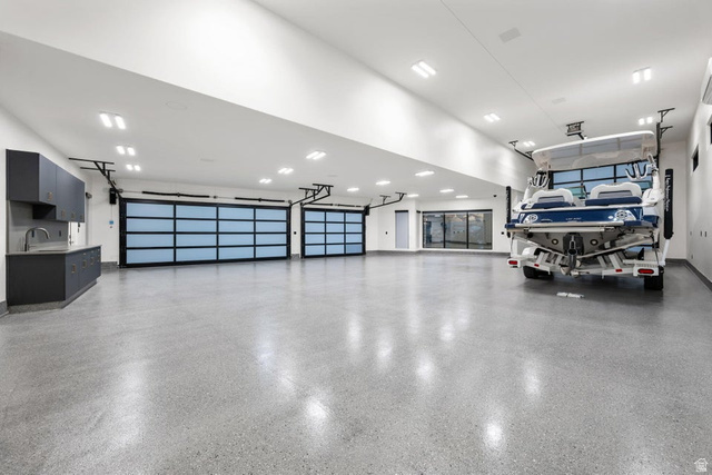 2867 East Granite Way St. George, UT 84790 - Photo 58 of 69 Spacious garage featuring two translucent panel garage doors, concrete flooring, recessed lighting, and built-in cabinetry with a sink