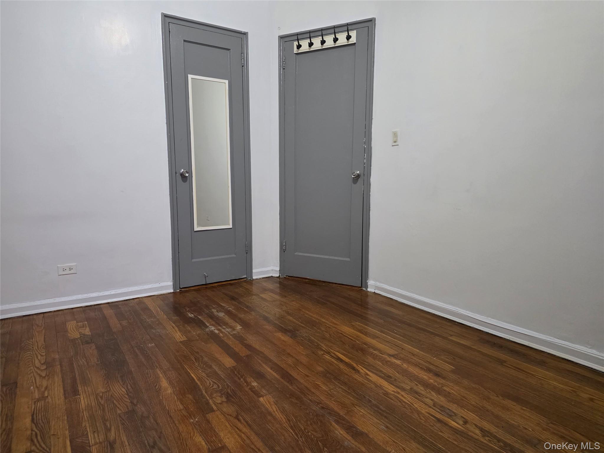 65-70 Booth Street, Unit 2B Queens, NY 11374 - Photo 5 of 8 a view of an empty room with wooden floor and a window