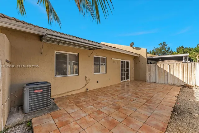 a backyard of a house with glass top table and chairs