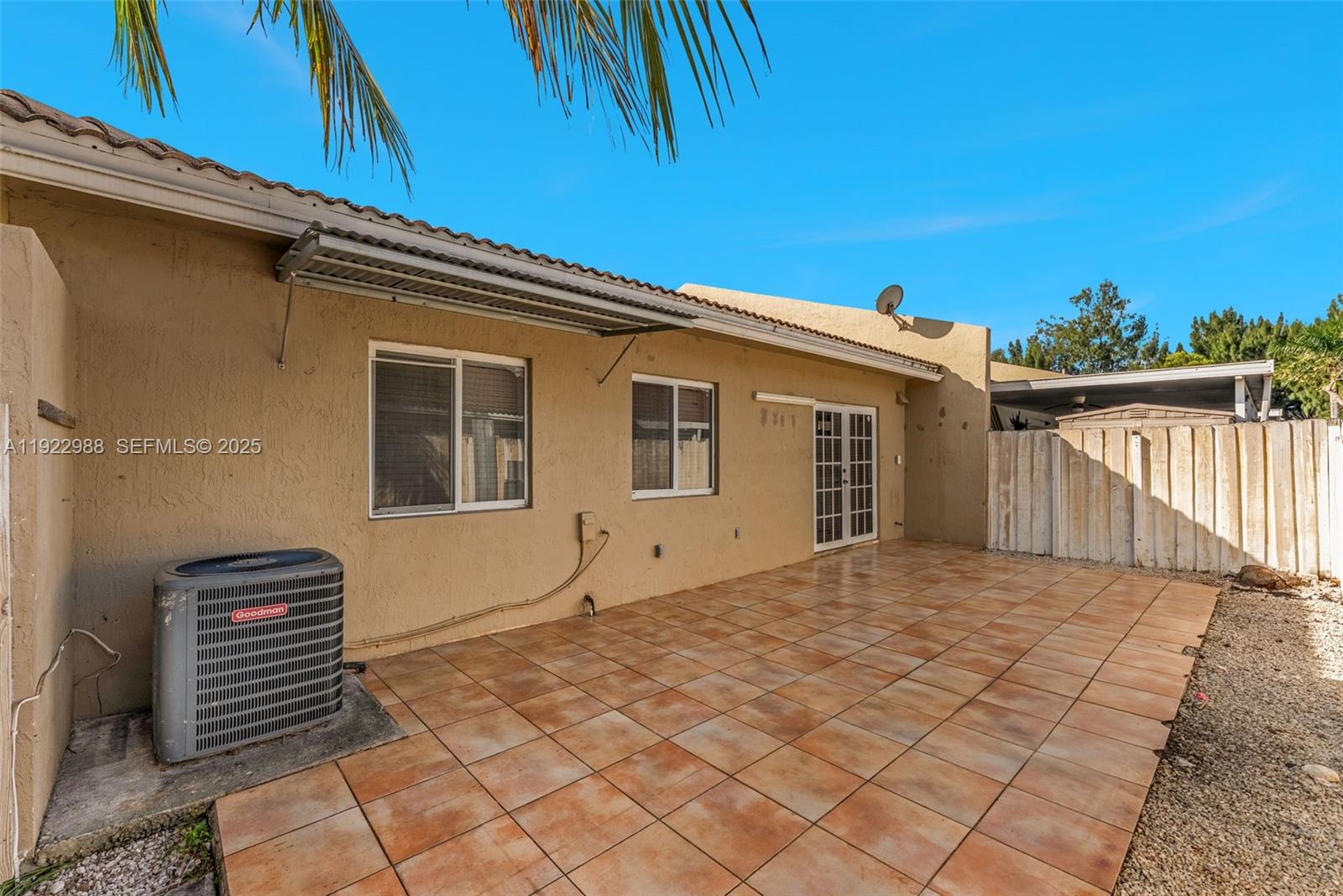 7665 Northwest 183rd Terrace, Unit 1405 Hialeah, FL 33015 - Photo 19 of 26 a backyard of a house with glass top table and chairs