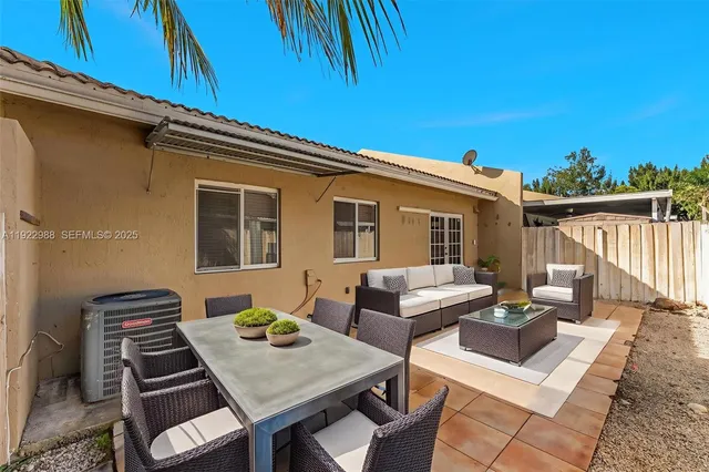 a view of a patio with couches and table and chairs with wooden floor