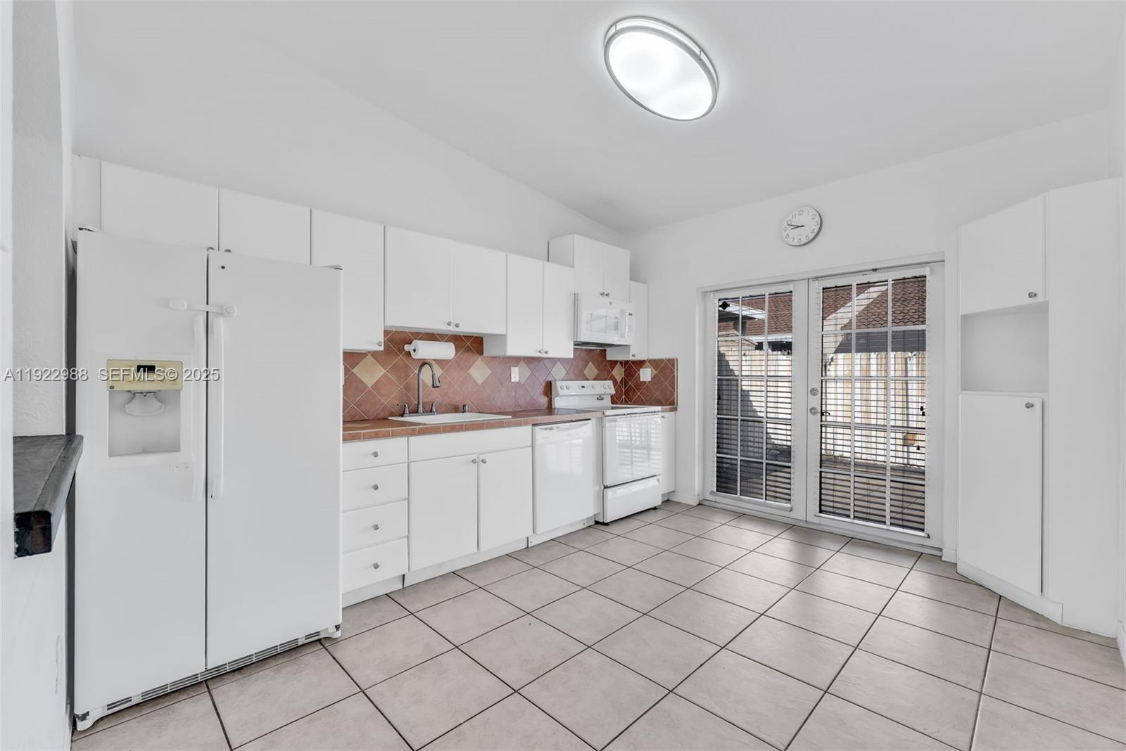 7665 Northwest 183rd Terrace, Unit 1405 Hialeah, FL 33015 - Photo 5 of 26 a kitchen with cabinets and window
