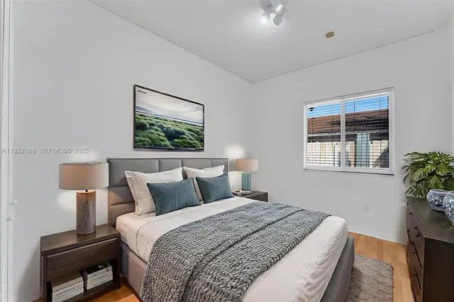 a bedroom with a bed and a potted plant next to a window
