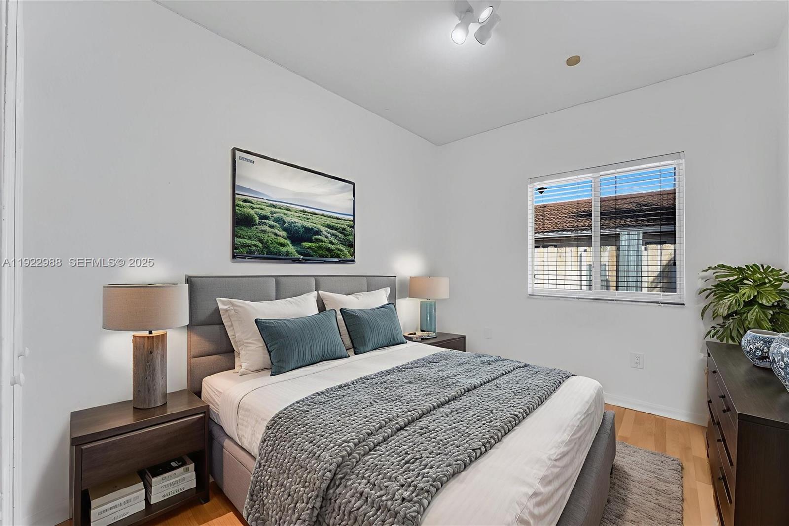 7665 Northwest 183rd Terrace, Unit 1405 Hialeah, FL 33015 - Photo 8 of 26 a bedroom with a bed and a potted plant next to a window