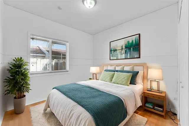 a bedroom with a bed and a potted plant