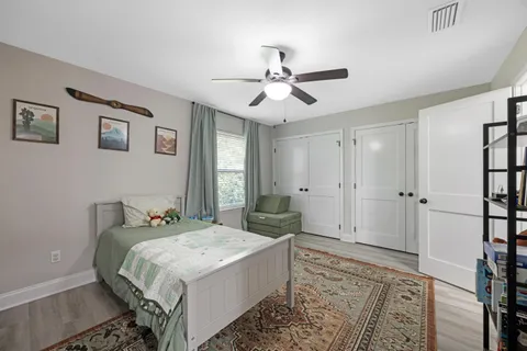 a bedroom with a bed cabinets and wooden floor
