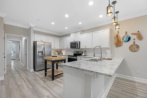 a kitchen with stainless steel appliances granite countertop a sink refrigerator and microwave