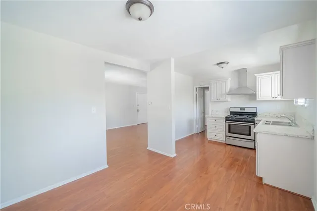 a kitchen with wooden floor and stainless steel appliances