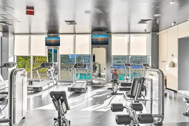 a room with gym equipment and large windows