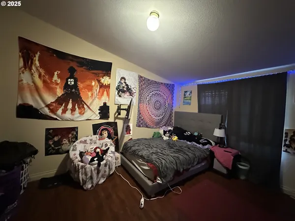 a bedroom with furniture and a painting on the wall