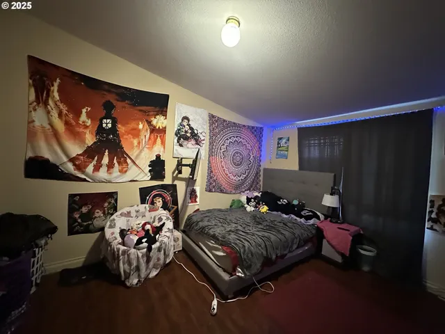 a bedroom with furniture and a painting on the wall