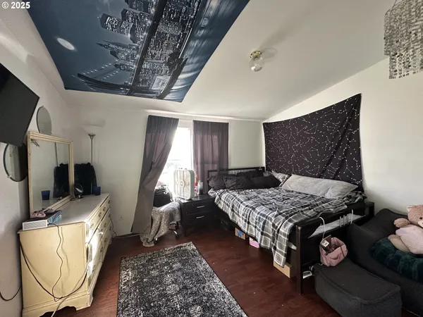 a bedroom with bed and a flat tv screen