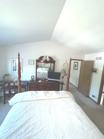 a bedroom with a large bed and a chandelier