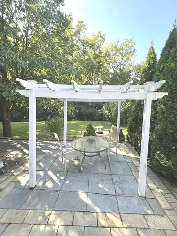 a view of a patio with a table chairs and a floor to ceiling window