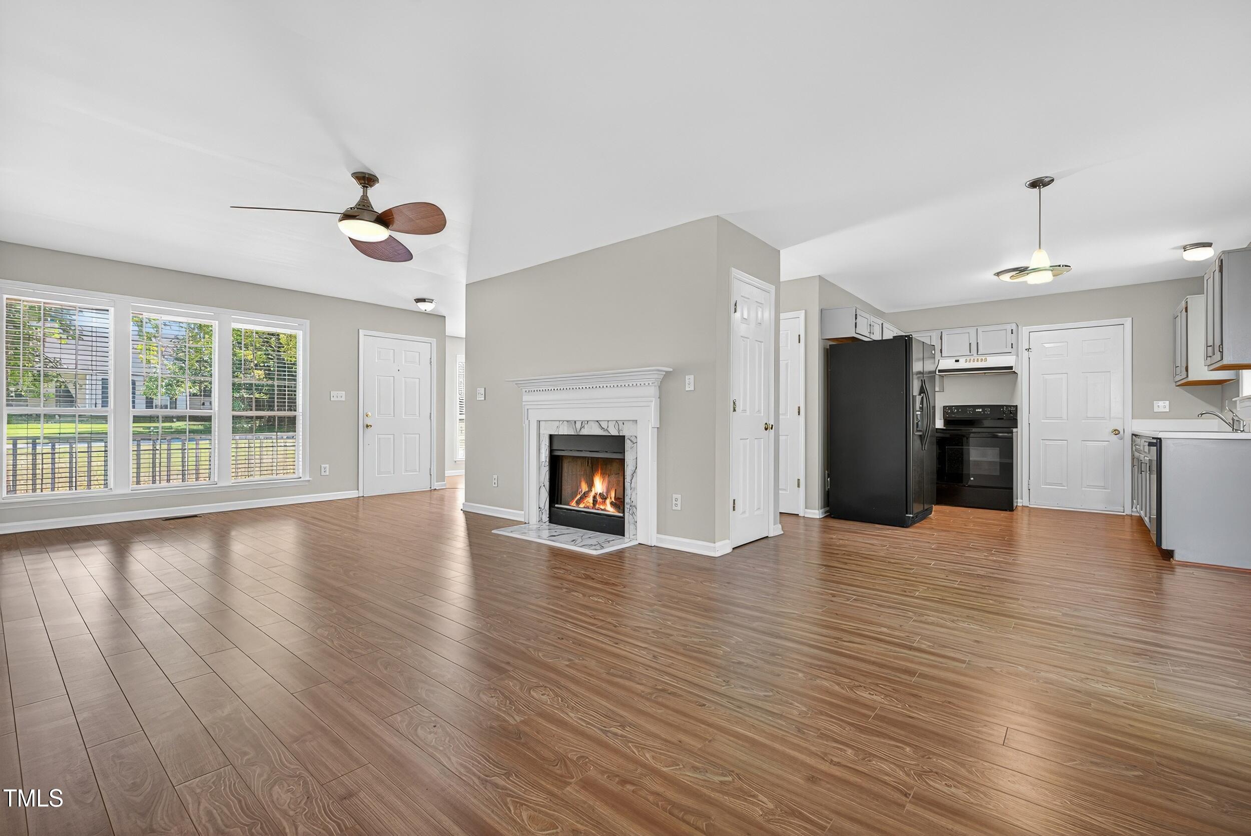 532 Baygall Road Holly Springs, NC 27540 - Photo 3 of 15 a view of an empty room with wooden floor and a kitchen