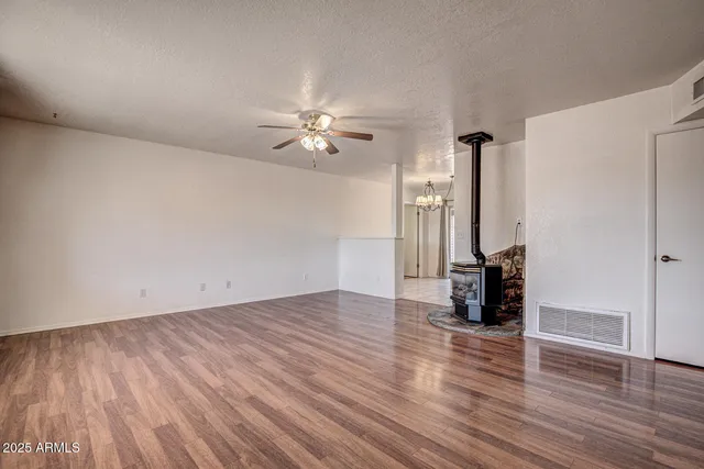 an empty room with wooden floor and ceiling fan