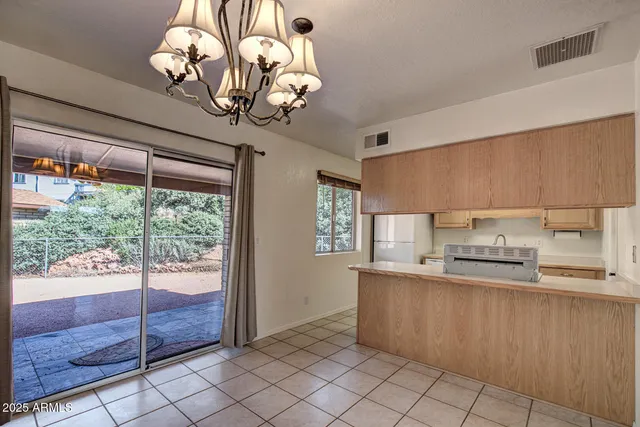 a kitchen with stainless steel appliances granite countertop a refrigerator a sink dishwasher a stove and a dining table with wooden floor