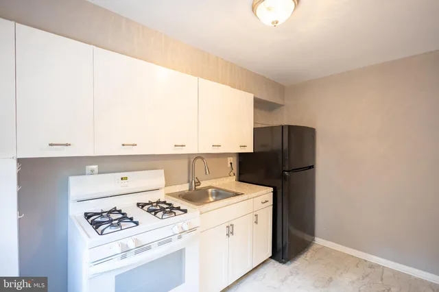 a kitchen with a stove a refrigerator and a window