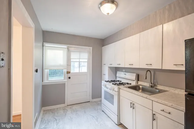 a kitchen with granite countertop a sink a window and cabinets