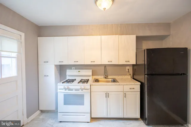 a kitchen with a refrigerator sink stove and cabinets