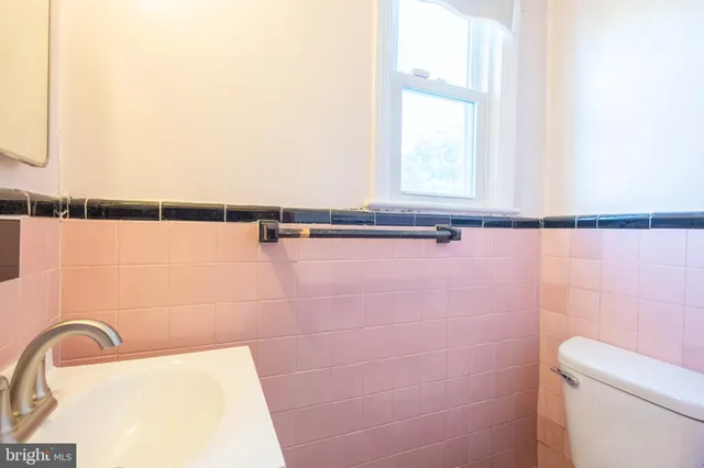 a bathroom with a sink a toilet and a mirror