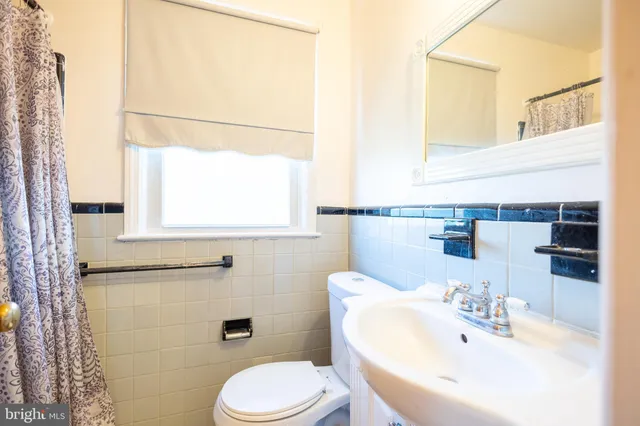 a bathroom with a sink mirror and toilet