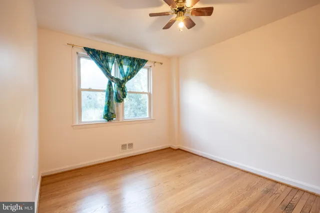 an empty room with a window and wooden floor