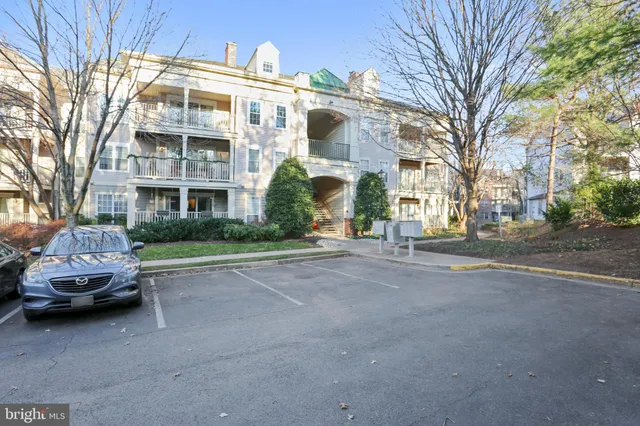 a front view of a building with cars parked on city street