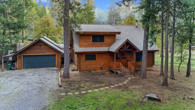 a view of a house with a yard and large tree