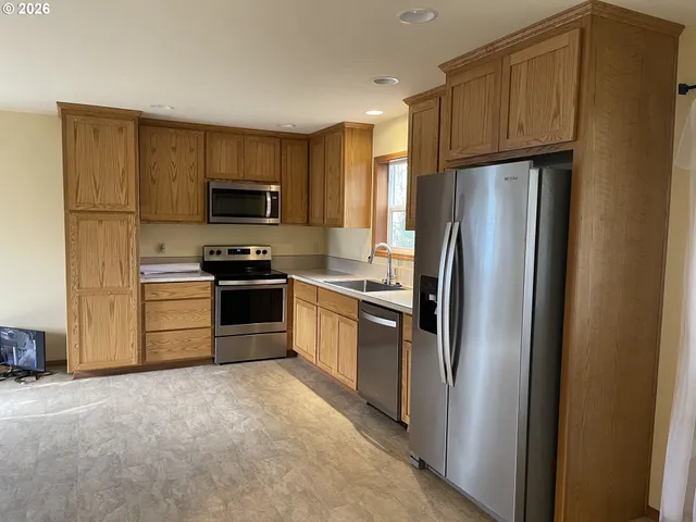 a kitchen with stainless steel appliances granite countertop a refrigerator stove a sink and dishwasher