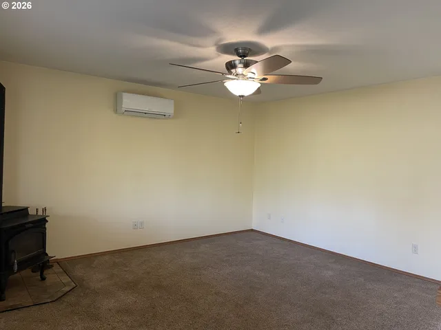 an empty room with a window and ceiling fan