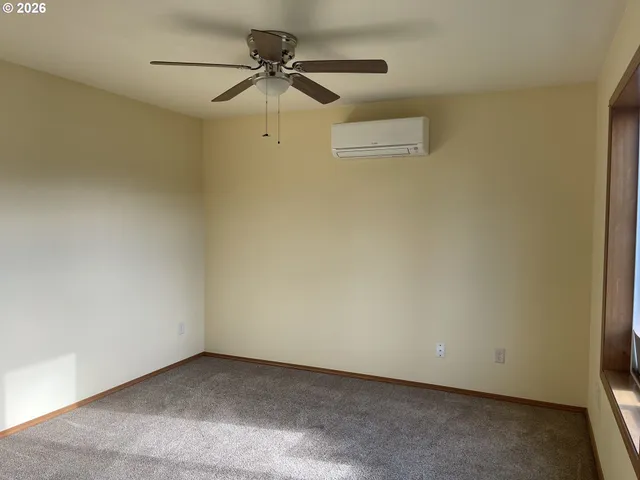 an empty room with a ceiling fan and a window