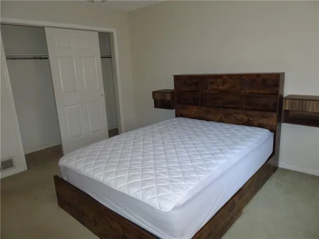 a bed sitting in a bedroom next to a cabinet
