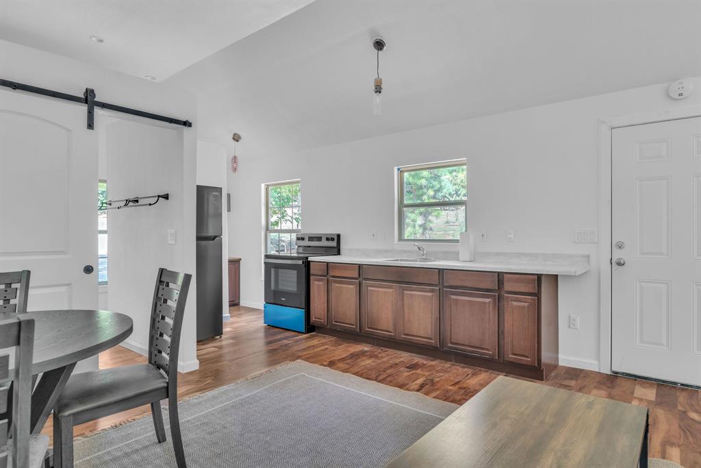 860 County Road 1627 Rusk, TX 75785 - Photo 24 of 37 a kitchen with stainless steel appliances kitchen island granite countertop a refrigerator a stove a sink dishwasher with a dining table and chair