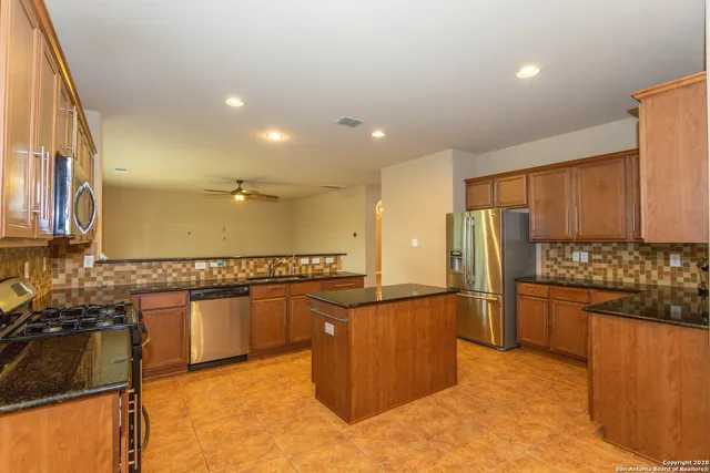 a kitchen with stainless steel appliances granite countertop a refrigerator and a stove