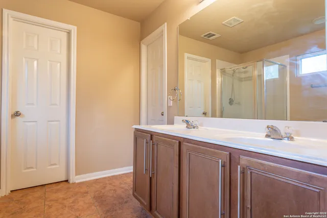 a bathroom with a double vanity sink and a mirror
