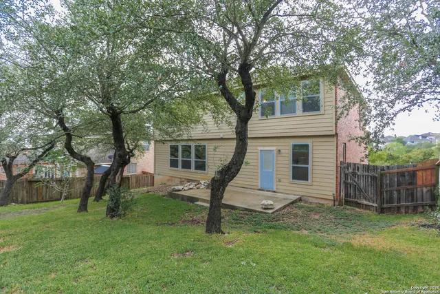 a view of a house with backyard and a tree