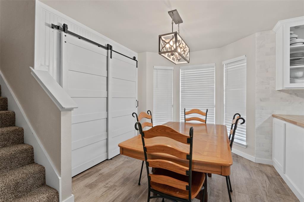 107 High View Court Decatur, TX 76234 - Photo 7 of 9 Dining area with a barn door, light wood-style flooring, and hanging lights