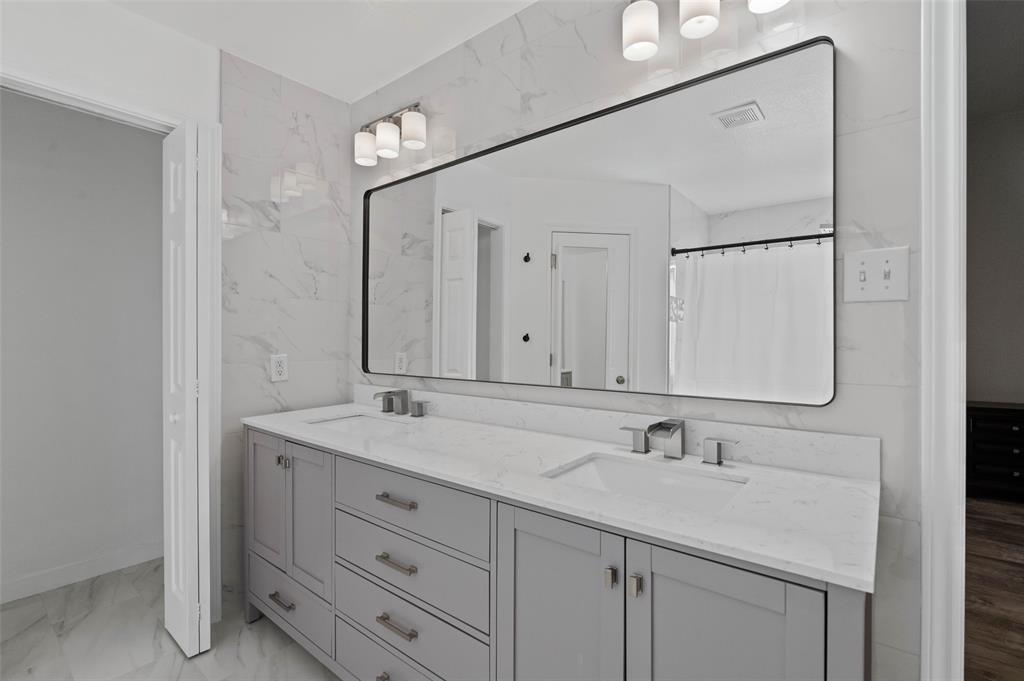 107 High View Court Decatur, TX 76234 - Photo 9 of 9 Full bath with double vanity, curtained shower, and light marble finish flooring