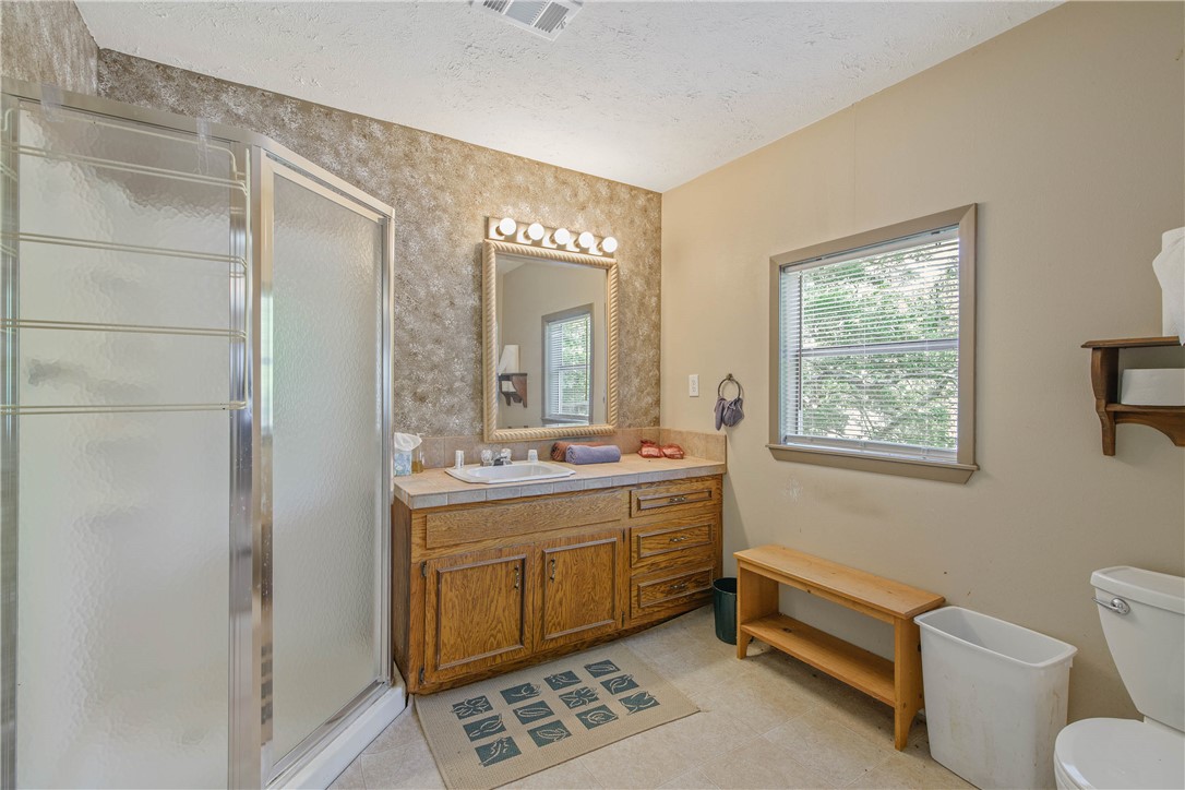 11001 Clyde Acord Road Franklin, TX 77856 - Photo 39 of 43 a spacious bathroom with a mirror a toilet a sink and a window