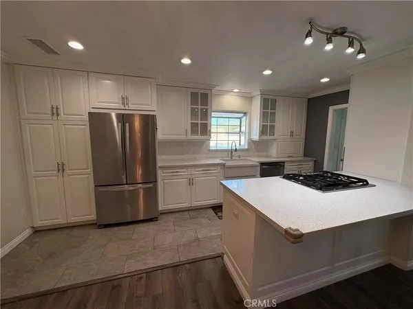 a view of an empty room with kitchen and a window