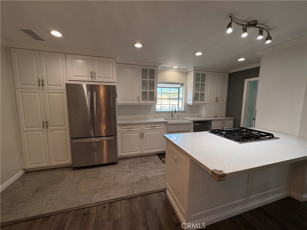 1721 East Ruddock Street Covina, CA 91724 - Photo 7 of 29 a kitchen that has a refrigerator a sink and white cabinets