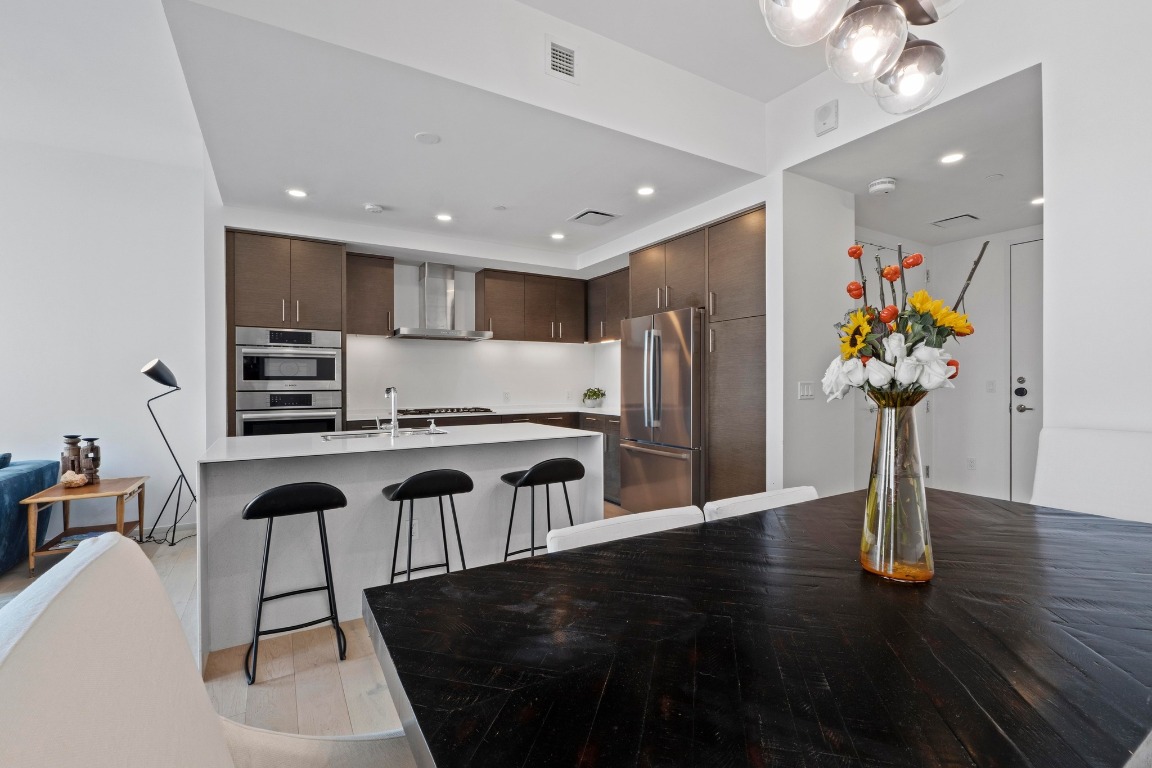 301 West Avenue, Unit 2708 Austin, TX 78701 - Photo 12 of 27 a kitchen with stainless steel appliances granite countertop a refrigerator a stove a sink dishwasher and microwave with wooden floor