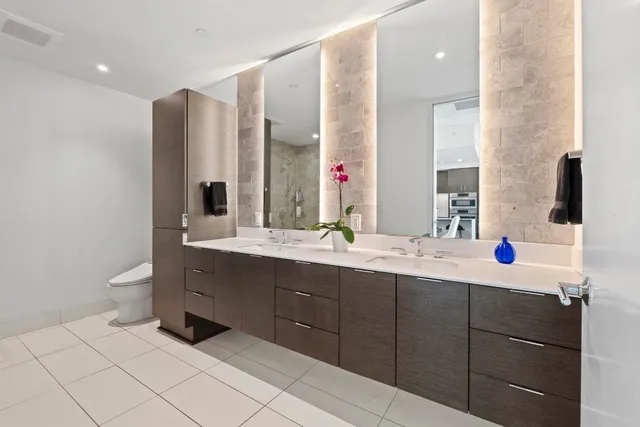a bathroom with a double vanity sink mirror and toilet