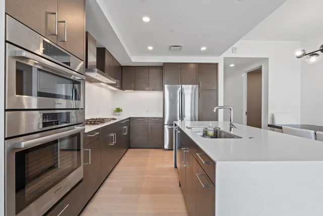 a large kitchen with stainless steel appliances granite countertop a sink and a stove
